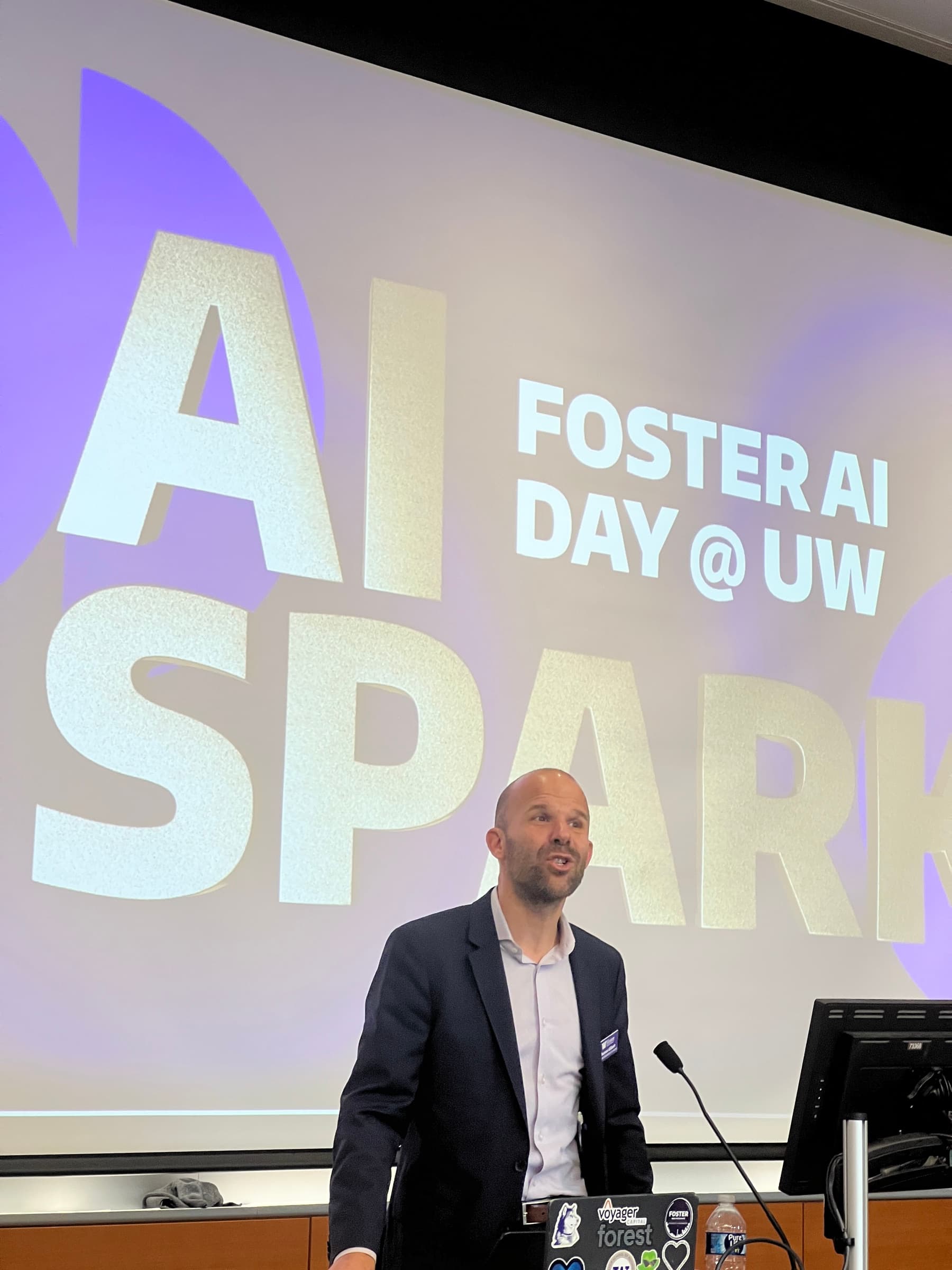 A speaker at the lectern with AI Spark projected behind him.