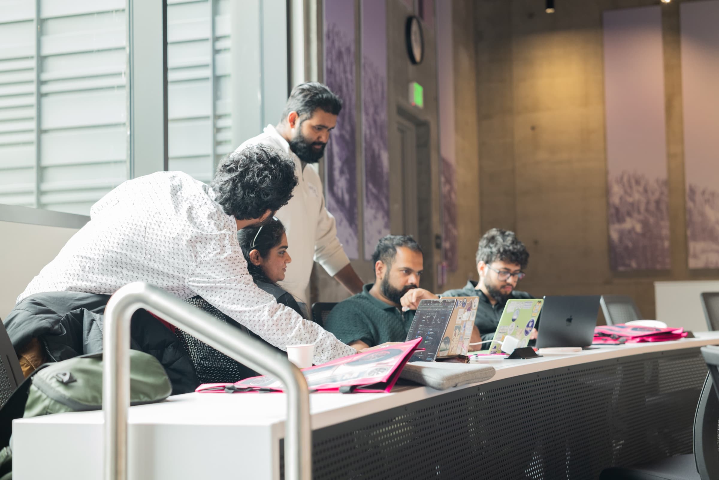 A team gathered around laptops in the hackathon classroom.