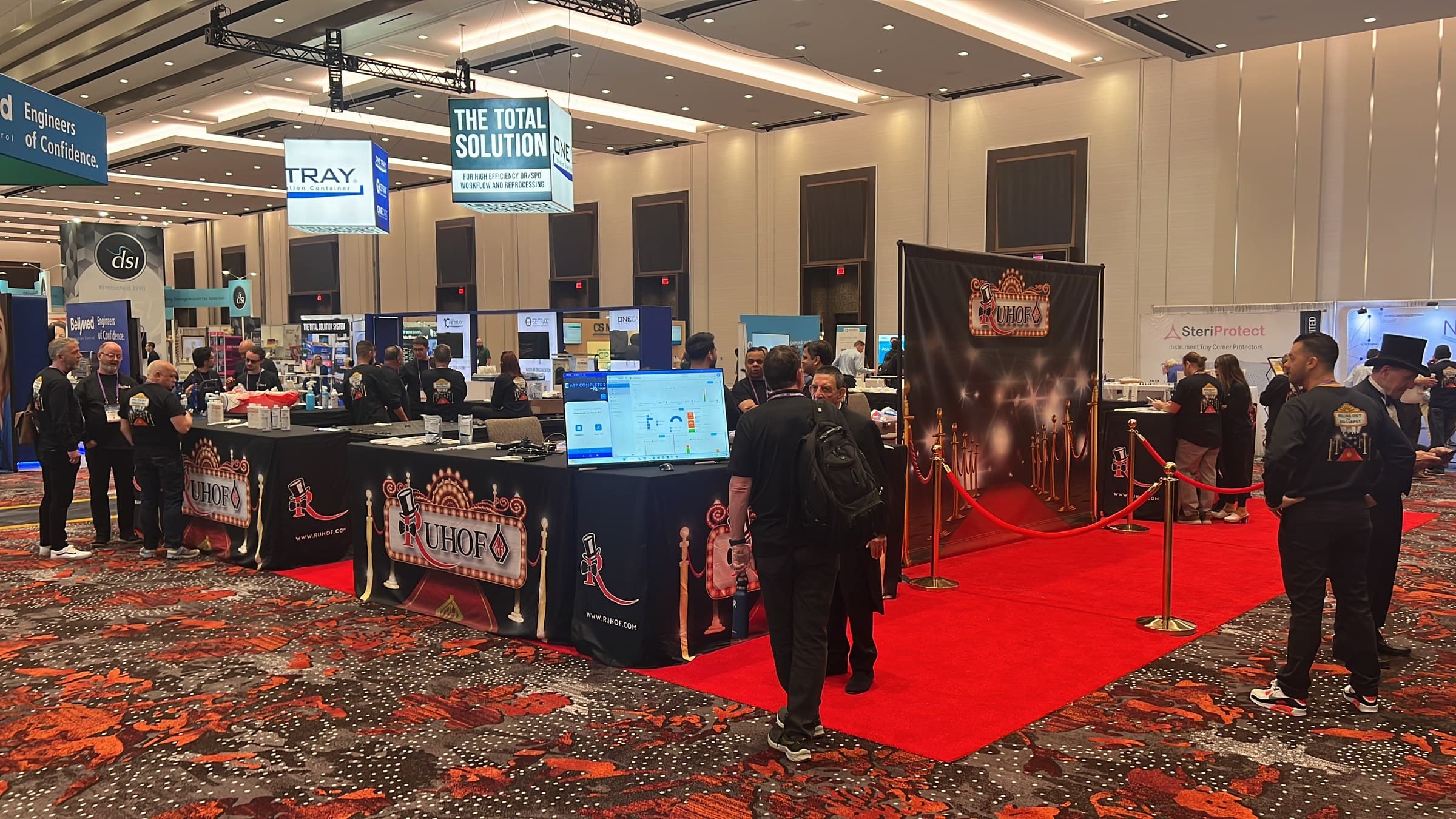 Trade-show booth with Ruhof branding, product displays, and an ATP Complete 2 software screen.