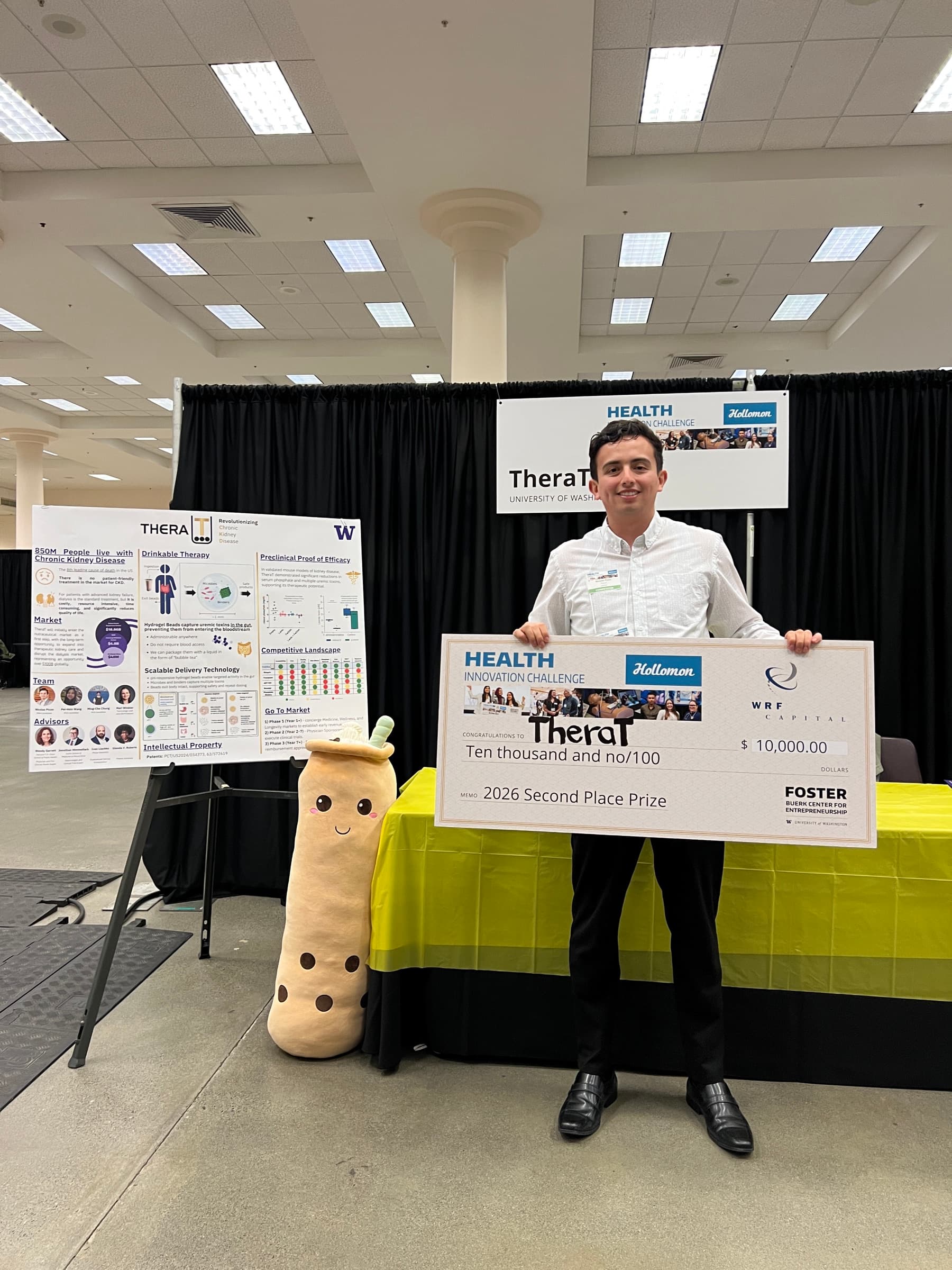 Nicolas holding TheraT’s second-place prize check at the team’s exhibit.
