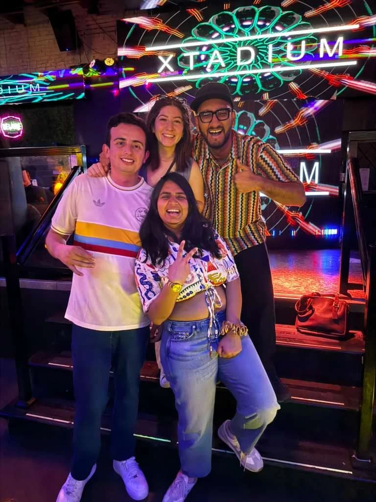 Nicolas and classmates posing together beside the Xtadium stage.